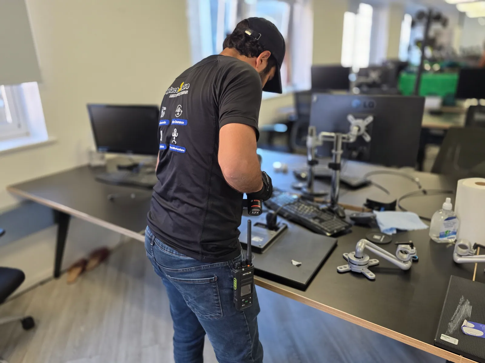 Oneplace2save team member dismantling equipment at an office workstation