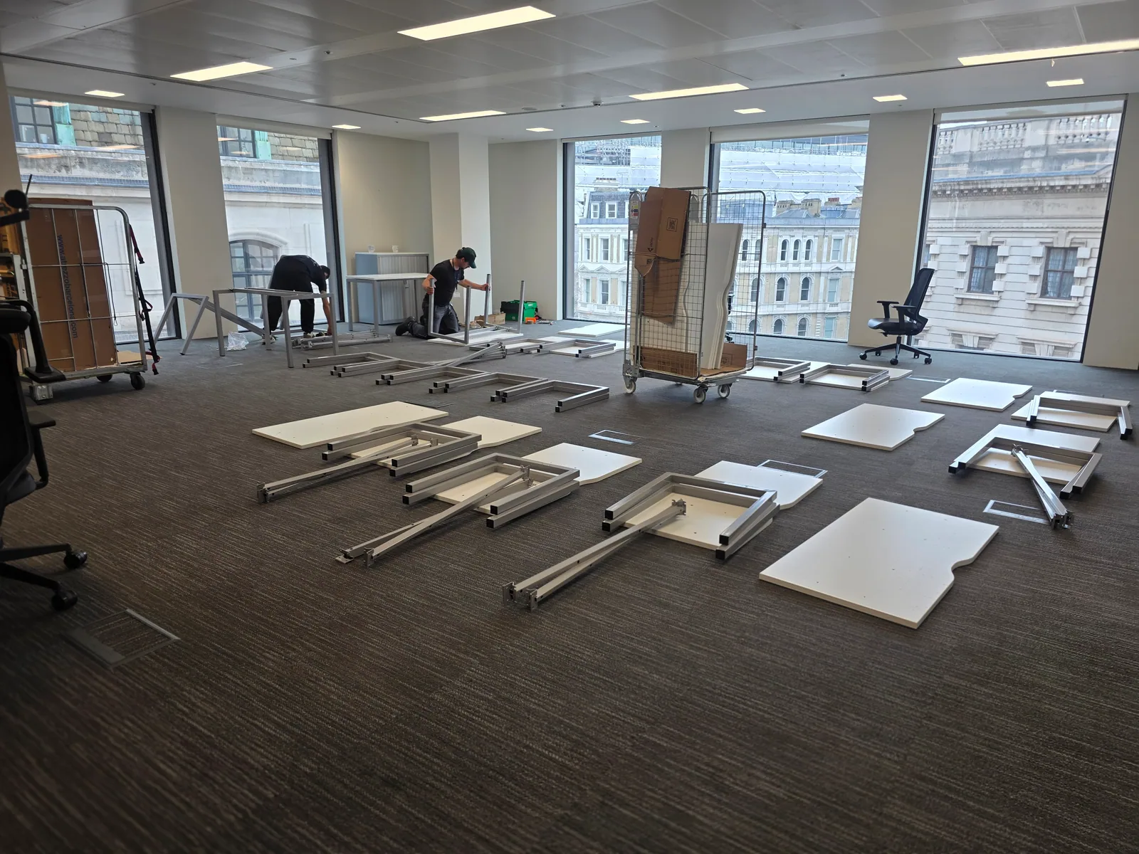 Oneplace2save crew dismantling office desks and organising furniture panels