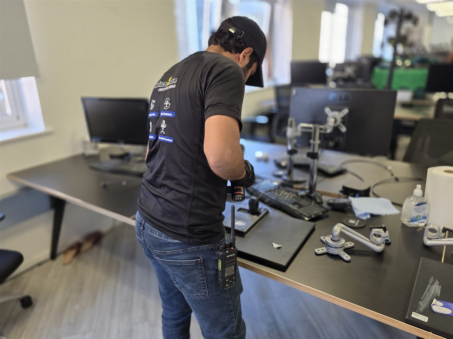 Oneplace2save team member using a cordless drill to dismantle office furniture.