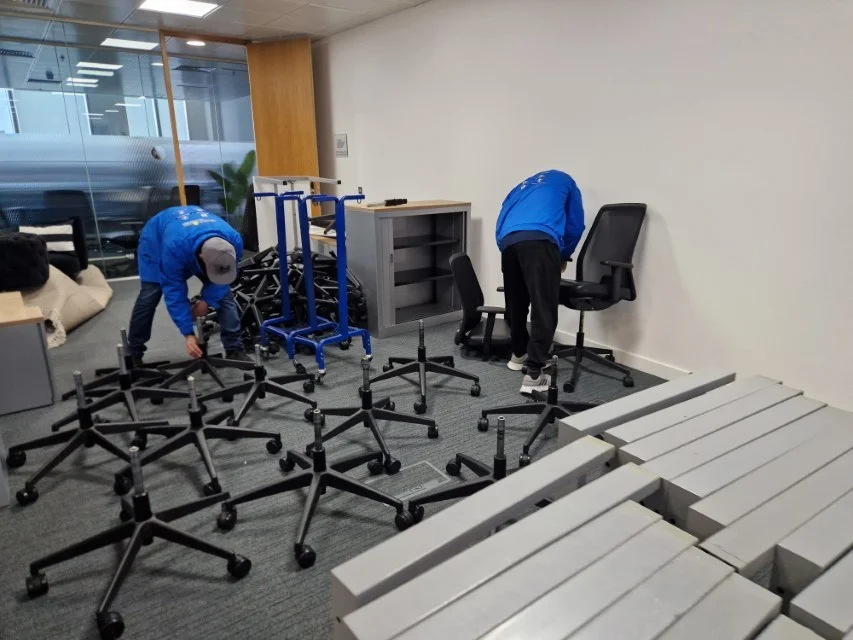 Oneplace2save team handling office chairs and dismantled furniture.