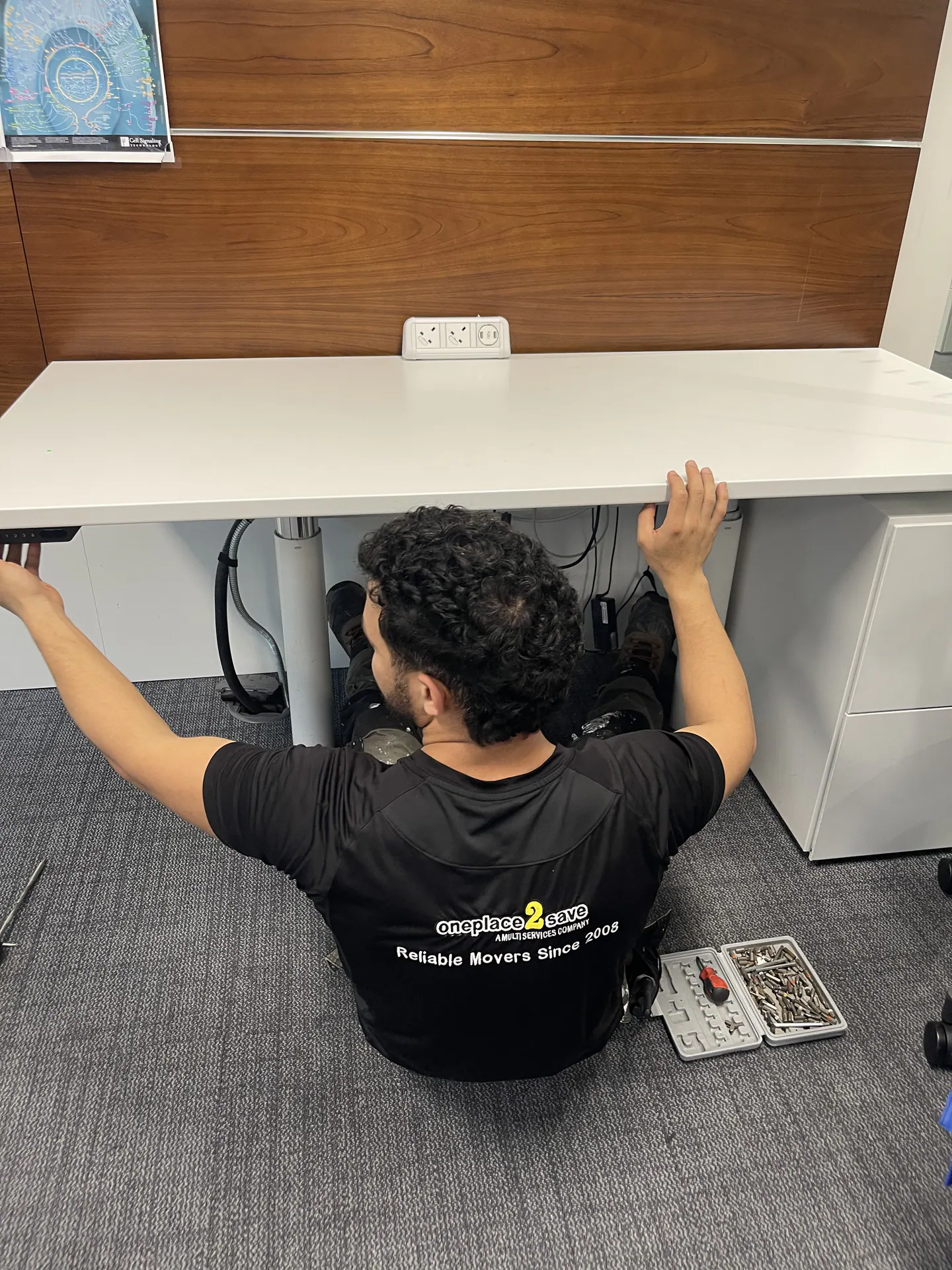 Oneplace2save technician installing a sit-stand desk at Evercore London.