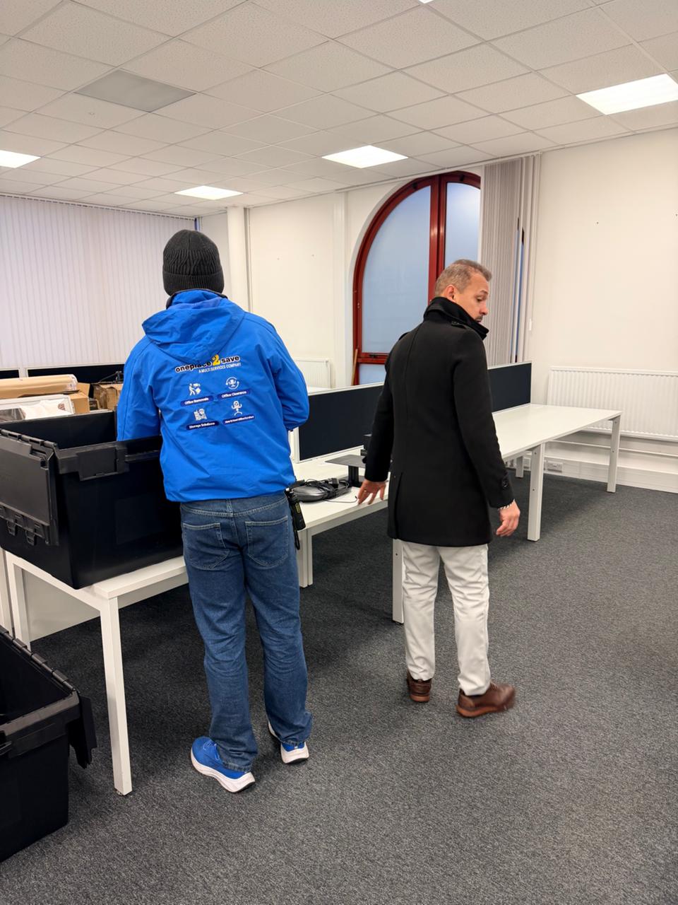 Oneplace2save team member beside installed desks during a workplace walkthrough for the McLaren relocation.