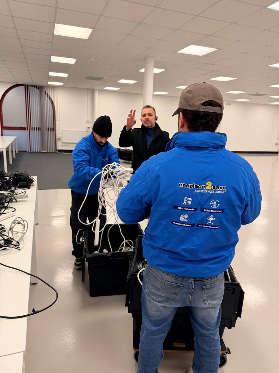Oneplace2save team members sorting cables and equipment into reusable moving crates during the McLaren relocation.